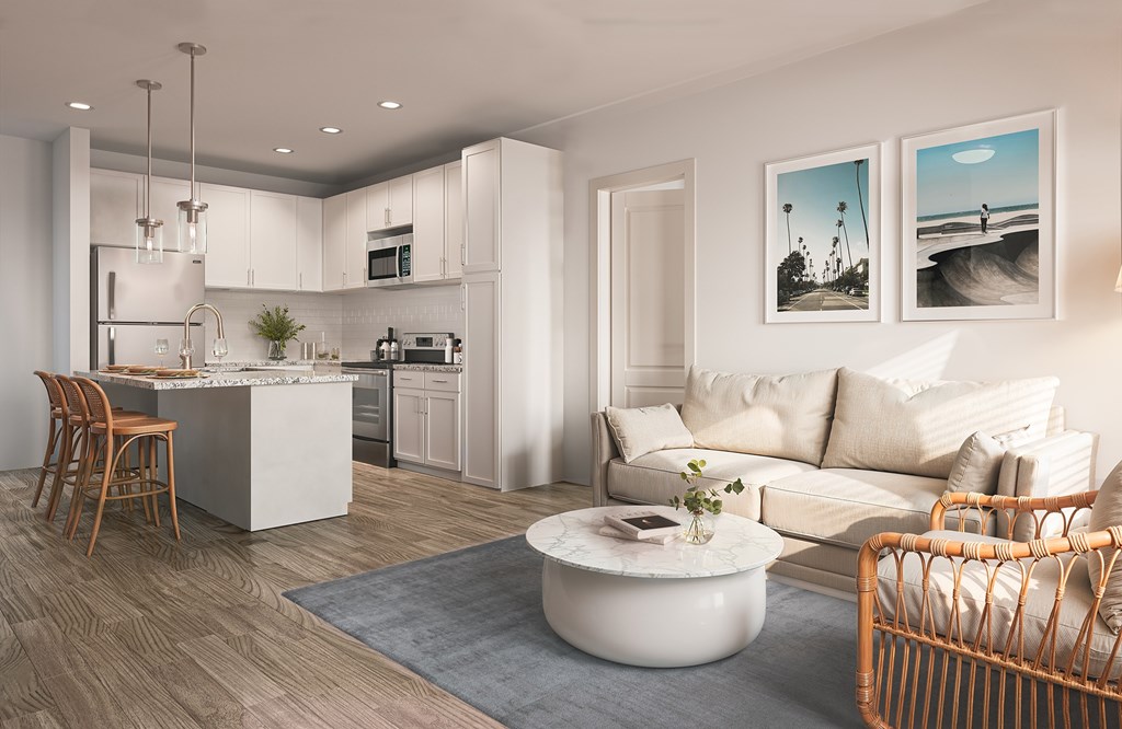 A modern living room with a kitchen area in the background.