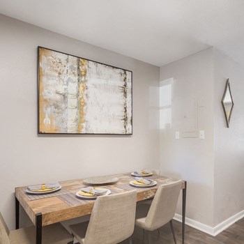Model dining area with a rectangular table set with place settings and 4 chairs at Ascend at Savannah