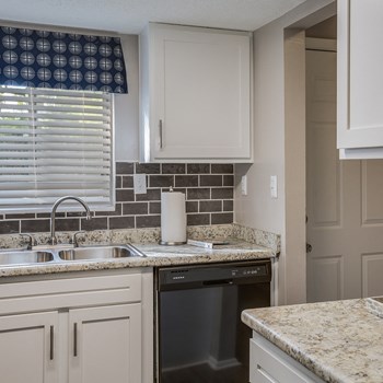 Model kitchen with a dishwasher and subway tile backsplash at Ascend Midtown apartments in at Savannah