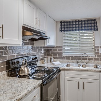 Model kitchen has modern appliances, granite counters and a double sink at Ascend Midtown apartments in at Savannah
