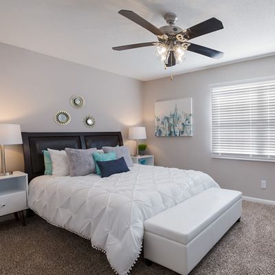 Spacious model bedroom with carpeted floors and room for a king sized bed, and nightstands at Carriage House Apartments