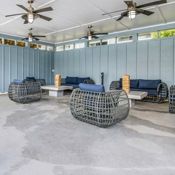Outdoor patio area with grey seating options at the Falls at Spring Creek Apartment Homes in Macon, GA