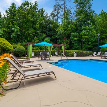 Pool pavilion with sundeck lounge chairs and umbrellas at TEN35 Alexander in Augusta, GA