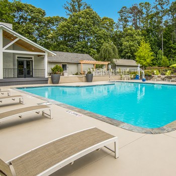 Sparkling swimming pool with lounge chairs and sundeck at The Legacy at River Crossing in North Macon, GA