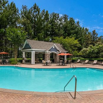 Sparkling swimming pool with lounge chairs at Heritage at Riverstone apartments in Canton, GA