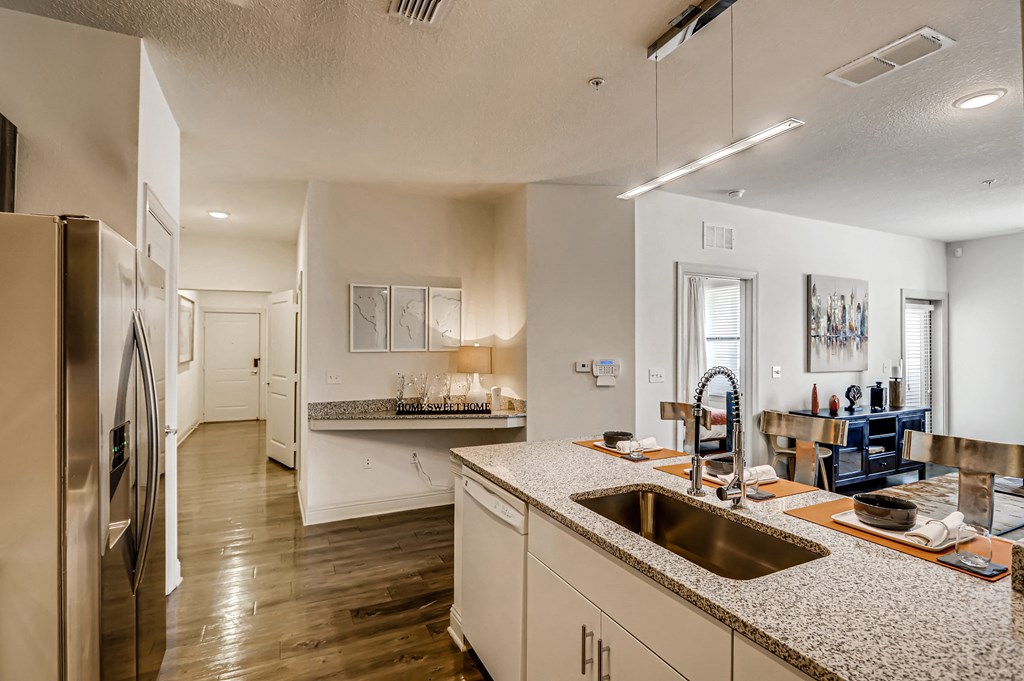 View from the kitchen of living area, bedroom entry, and hallway at EOS in Orlando, FL