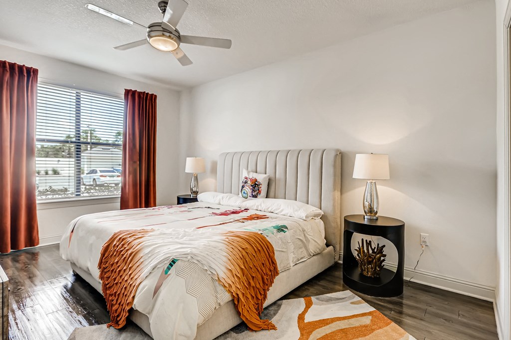 Bedroom with wood-designed flooring, window, and ceiling fan at EOS in Orlando, FL