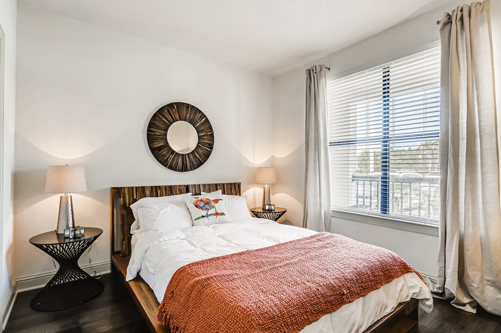 Bedroom with wood-designed flooring and large window at EOS in Orlando, FL