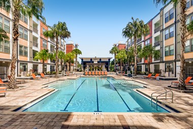 Resort-style swimming pool with lap lanes surrounded by tanning deck at EOS in Orlando, FL