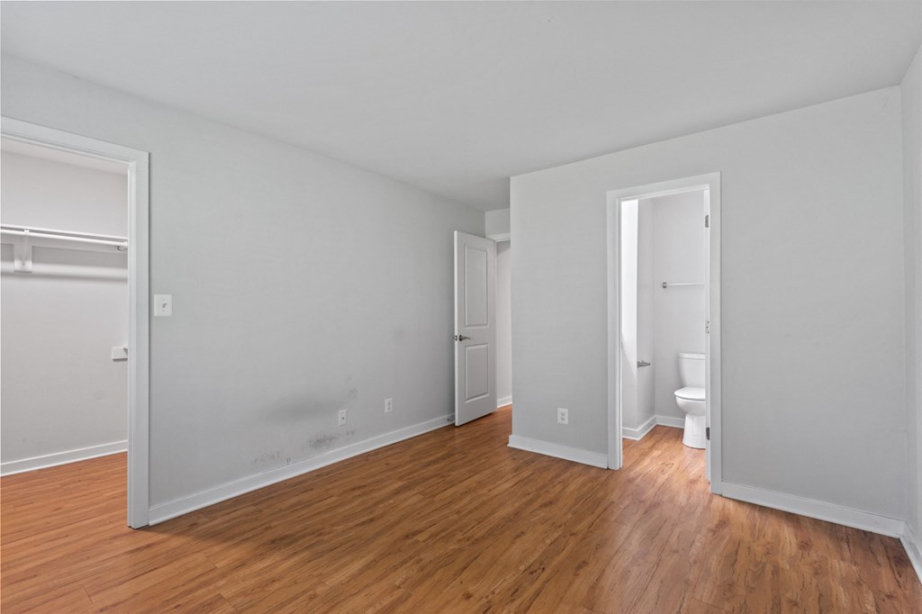 a bedroom with hardwood floors and grey walls