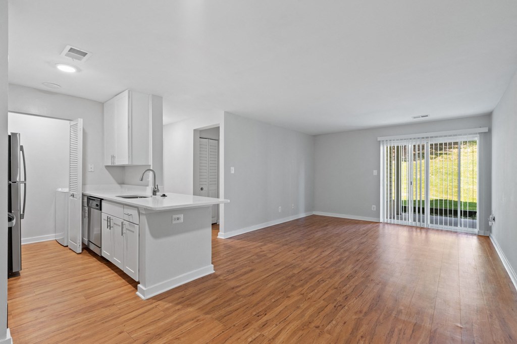 a living room and dining room with hardwood floors and a sliding glass door leading to a