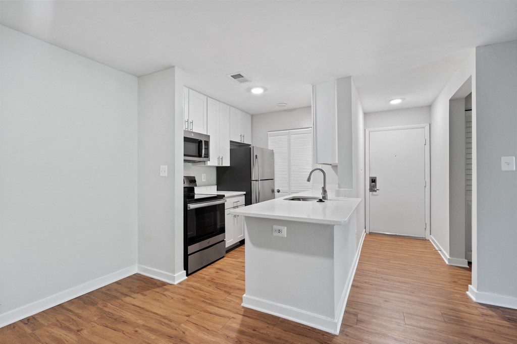 a kitchen with white cabinetry and a wooden floor