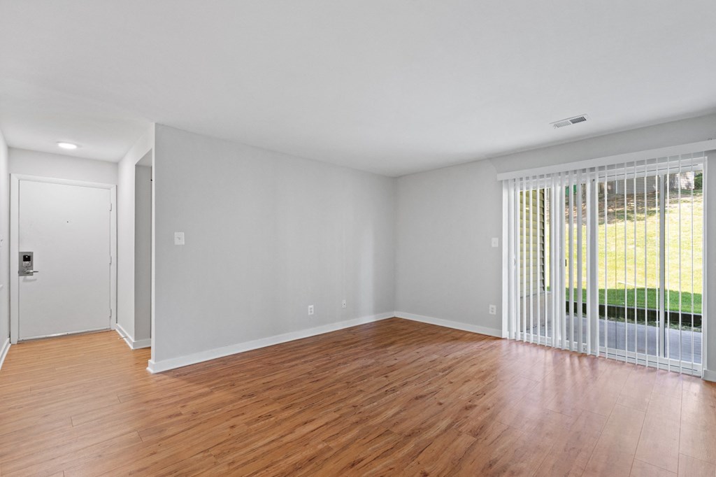 a bedroom with a sliding glass door and hardwood floors