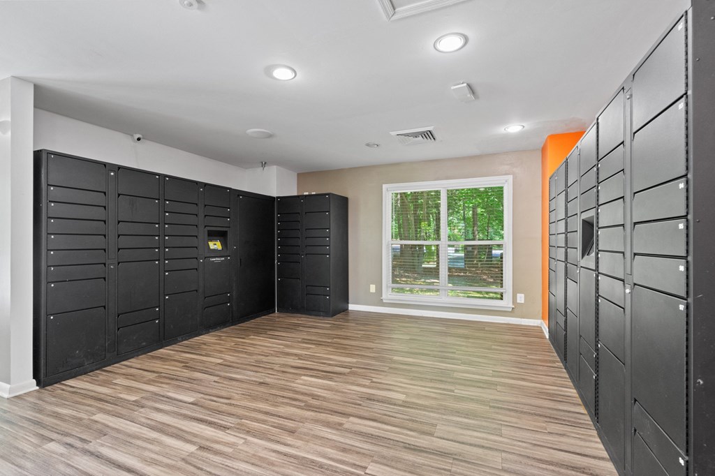 a photo of the inside of a locker room with black lockers and a window