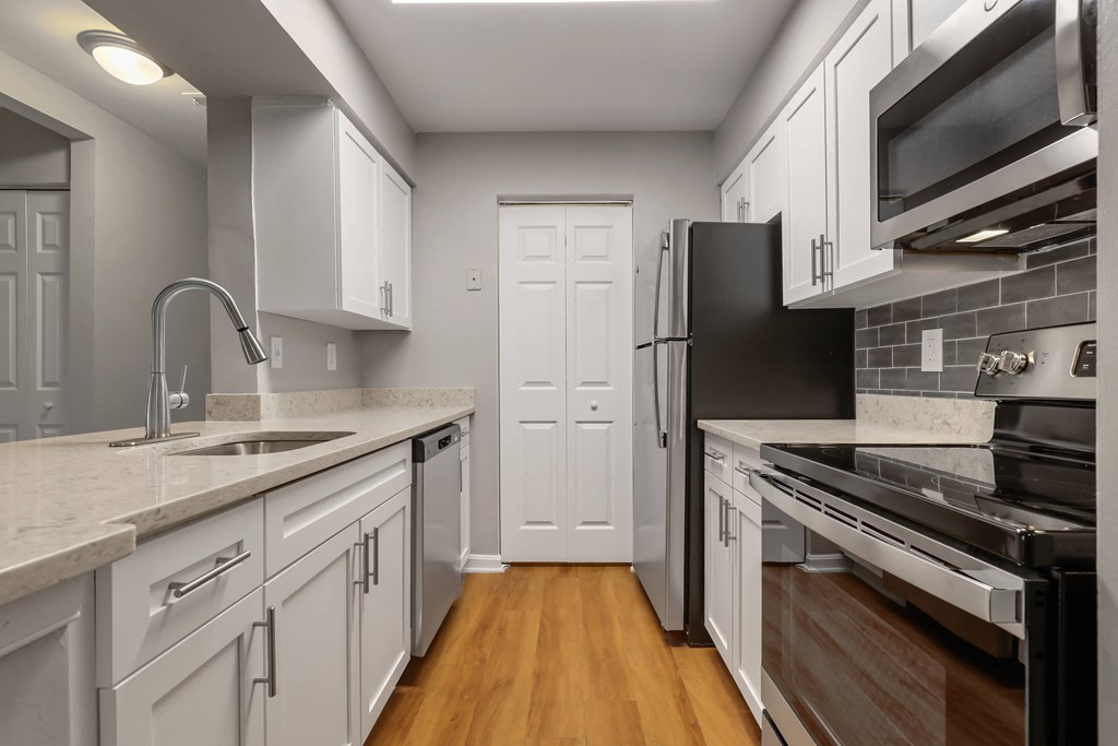 a kitchen with white cabinets and black appliances
