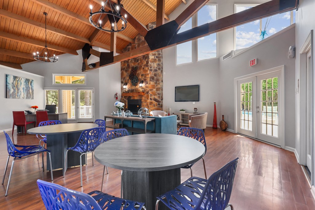 the gathering place at gardner village clubhouse with tables and chairs and a fireplace