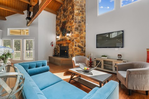 a living room with blue furniture and a stone fireplace