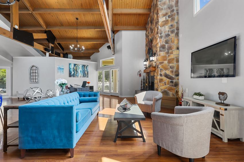 a living room filled with furniture and a large stone fireplace - Photo Gallery
