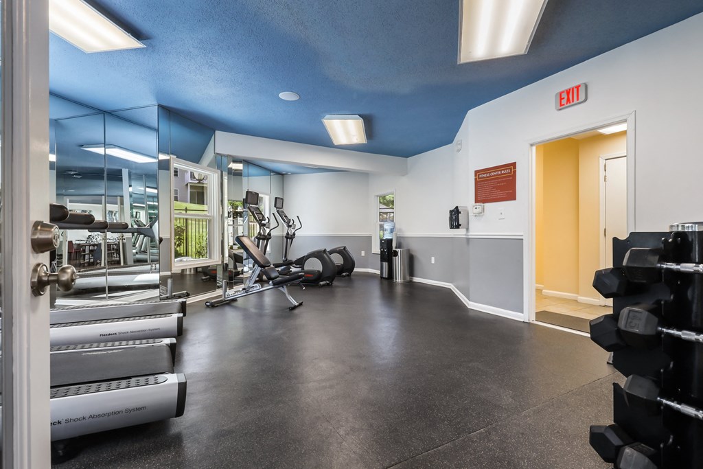 a fitness center with cardio machines and weights