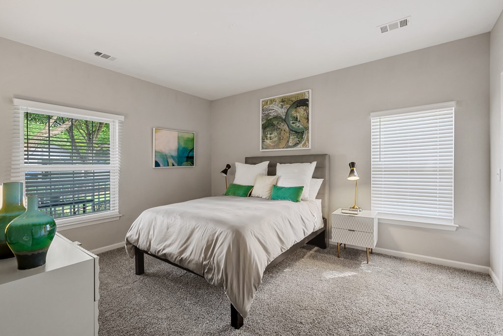 a bedroom with a bed and two windows