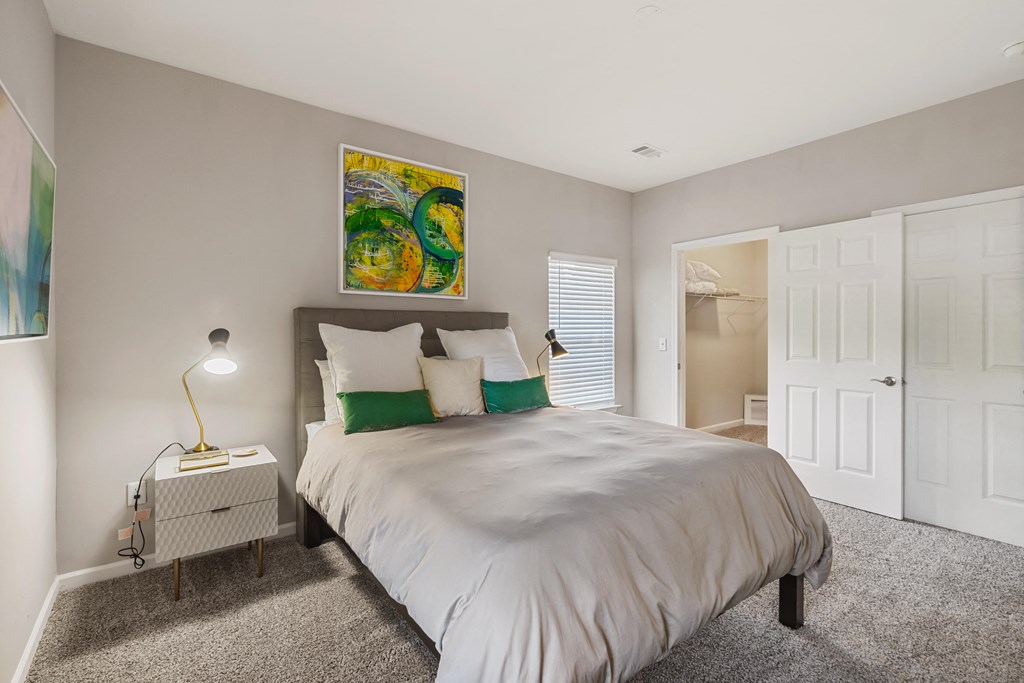 a bedroom with a bed and a nightstand with a lamp