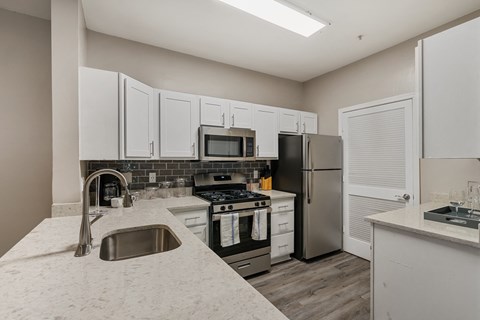 a kitchen with white cabinets and stainless steel appliances