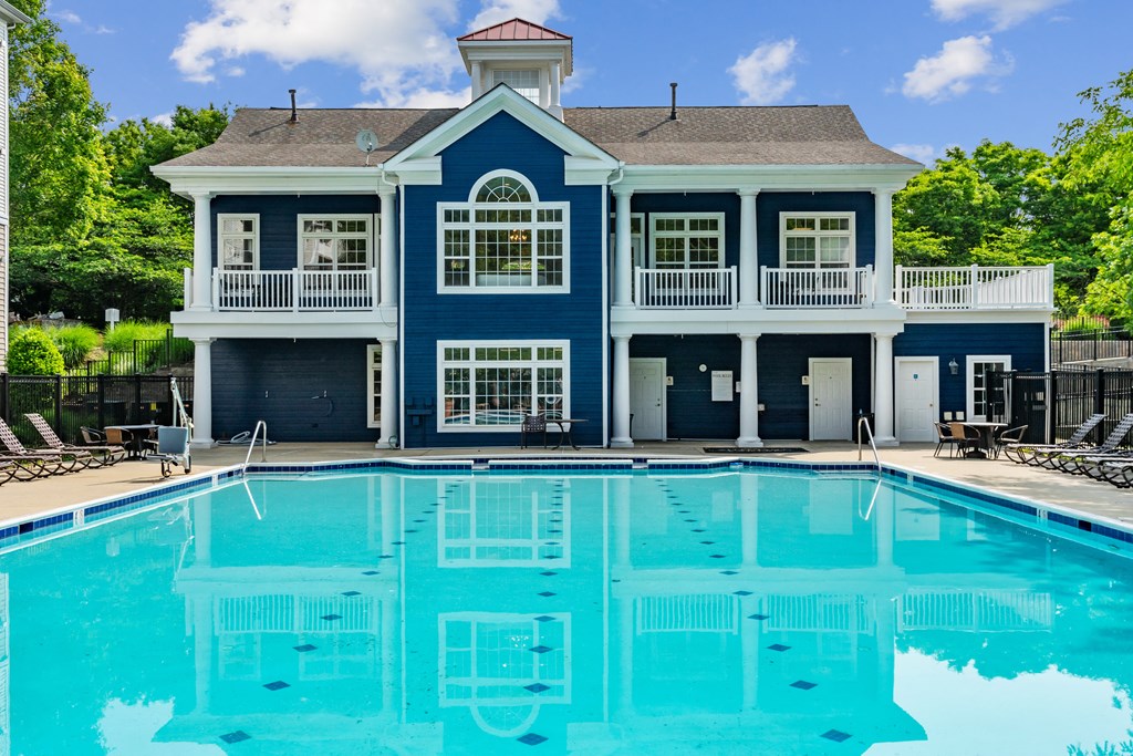 a large swimming pool with a blue building in the background