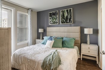 Bedroom with wood-designed flooring and door to the patio at Liberty Mill in Germantown, MD - Photo Gallery 26
