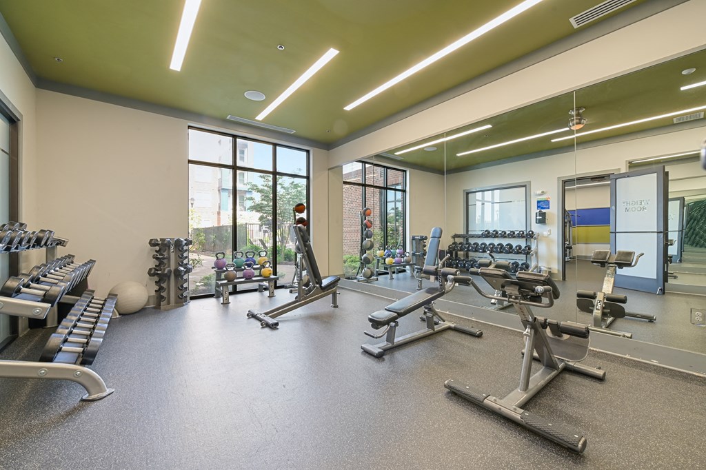 a view of the fitness center with cardio equipment and windows