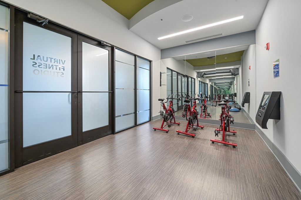 a room with a row of exercise bikes in front of a door with a sign that says