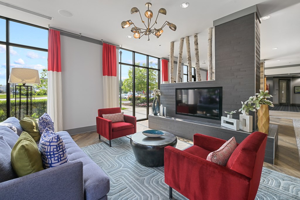 a living room with red chairs and blue couches