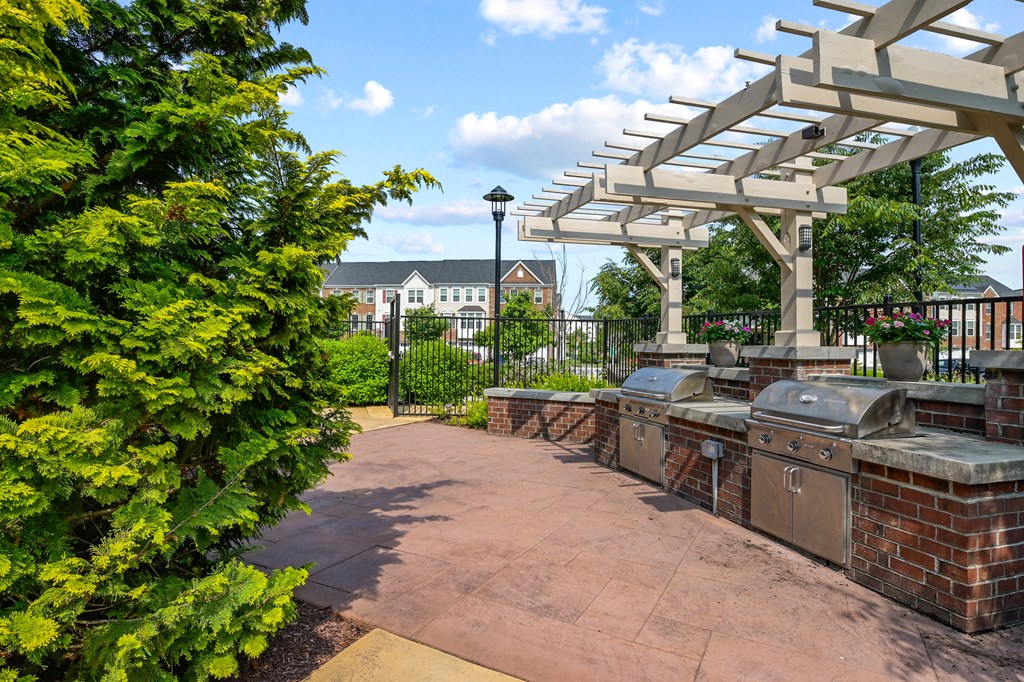 a patio with a barbecue grill and a pergola
