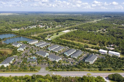 A bird's eye view of a resort with a large lake and a road. at Allegra at Cocoa in Cocoa, FL, 32926