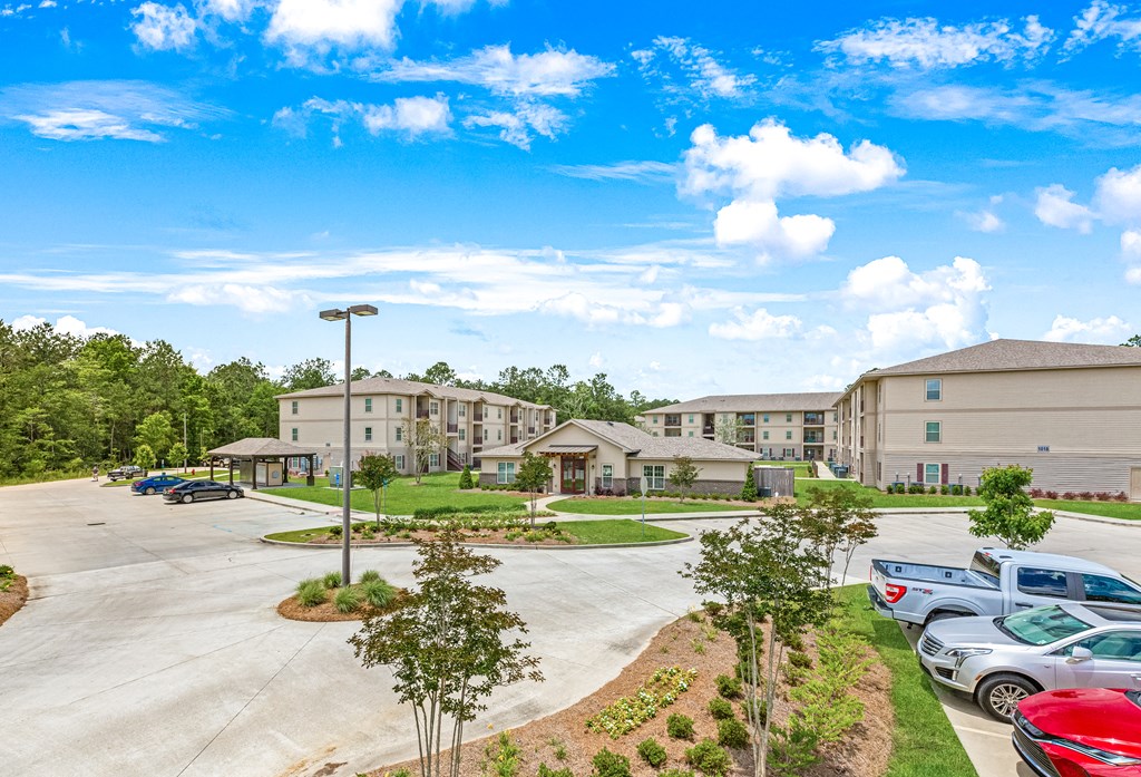 View of the property in Covington, LA with residential building, parking spaces and lush landscaping