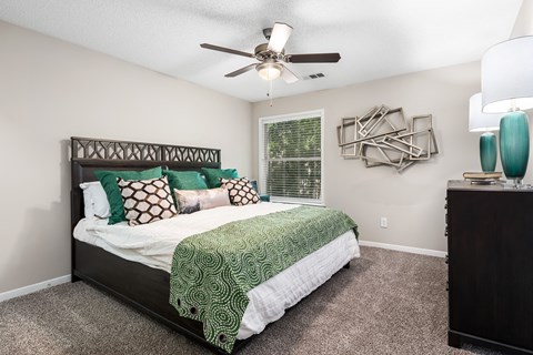 a bedroom with a bed and a ceiling fan