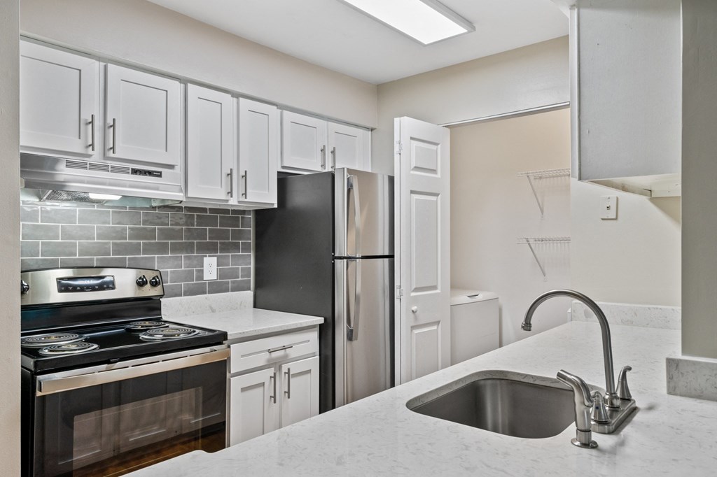 a kitchen with white cabinets and stainless steel appliances