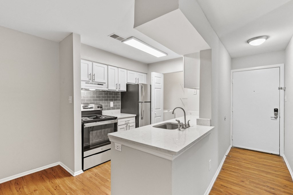 a kitchen with white cabinetry and stainless steel appliances