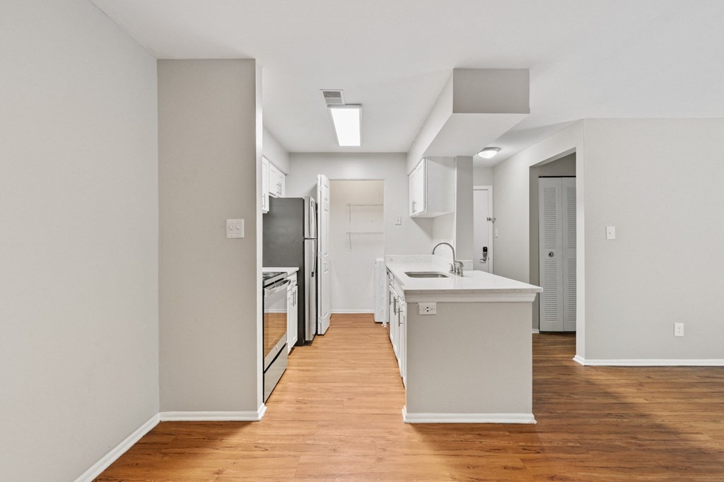 a kitchen with white cabinetry and a wooden floor
