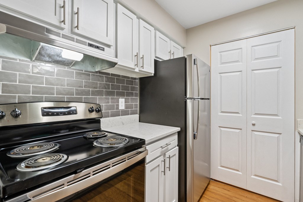 a kitchen with white cabinets and stainless steel appliances