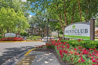 a sign that says huntingfield homes with flowers in front of it