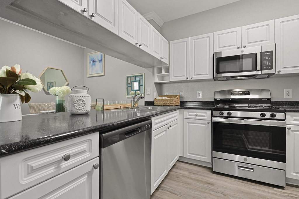 a kitchen with white cabinets and stainless steel appliances