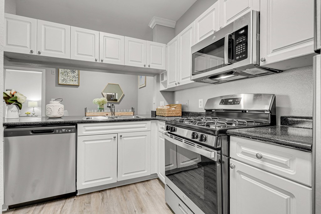 a kitchen with white cabinets and stainless steel appliances