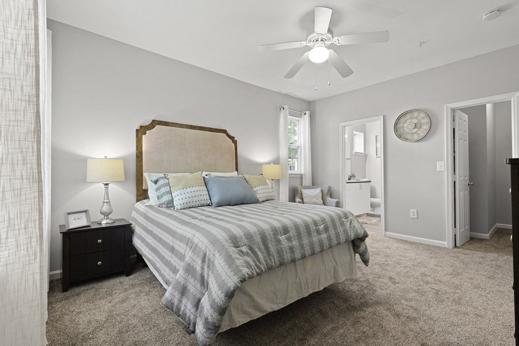 a bedroom with a large bed and a ceiling fan