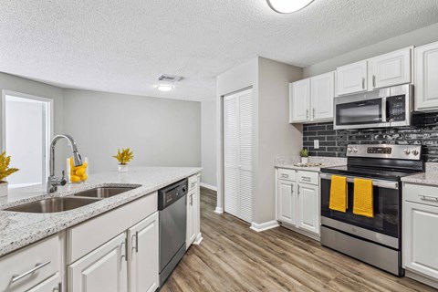 A kitchen with white cabinets and a black stove top oven.