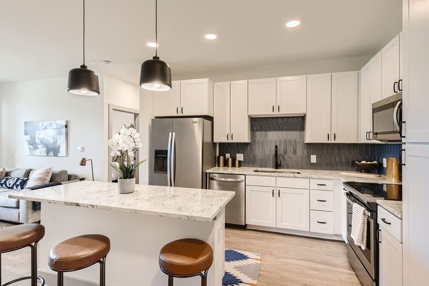 Kitchen with stainless steel appliances, granite counters, and island bar at Cypress McKinney Falls in Austin, TX - Photo Gallery