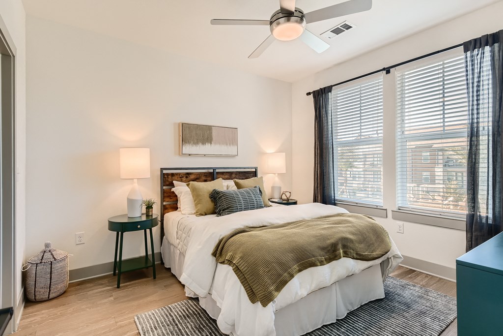 Bedroom with wood-designed flooring and large windows at Cypress McKinney Falls in Austin, TX