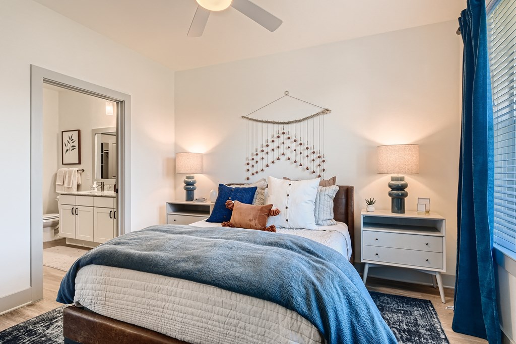 Bedroom with wood-designed flooring, ceiling fan, and private bath at Cypress McKinney Falls in Austin, TX