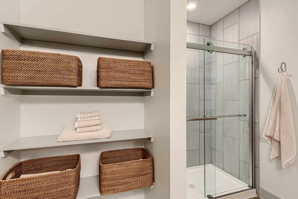 Bathroom with walk-in shower and built-in storage shelves at Cypress McKinney Falls in Austin, TX