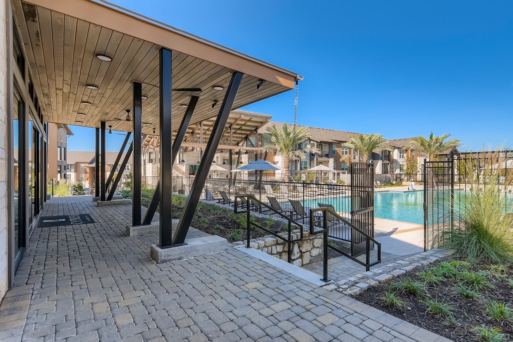 Clubhouse patio overlooking the resort-style swimming pool and sundeck at Cypress McKinney Falls in Austin, TX