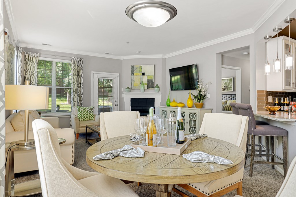 a living room with a table and chairs and a television in the background